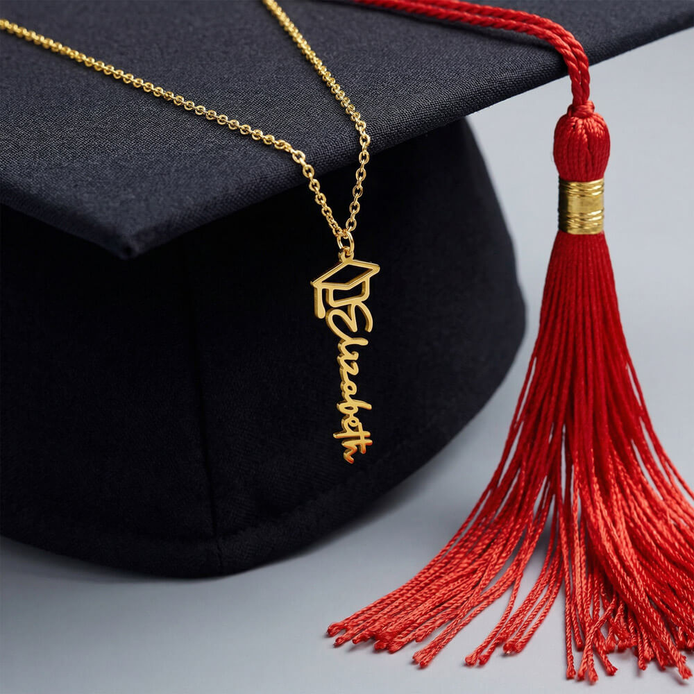 Custom personalised graduation cap name necklace featuring a script name pendant displayed on a real graduation cap with tassel, showcasing elegant graduation jewelry designed for women, high school and college grads, personalised gifts for her achievement, unique keepsake jewelry for graduation day photos, milestone celebration accessories, and meaningful custom name jewelry to honour academic success